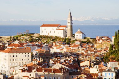 Eski şehir Piran 'ın tarihi merkezinin kırmızı çatıları, günbatımı gökyüzüne ve Adriyatik denizine karşı ana kilise. Hava manzarası, Slovenya