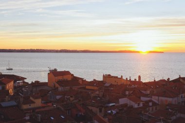 Eski şehir Piran 'ın tarihi merkezinin kırmızı çatıları günbatımına karşı gökyüzü ve Adriyatik denizi, hava manzarası, Slovenya