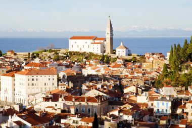 Eski şehir Piran 'ın tarihi merkezinin kırmızı çatıları, günbatımı gökyüzüne ve Adriyatik denizine karşı ana kilise. Hava manzarası, Slovenya