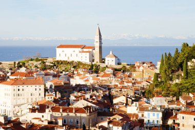 Eski şehir Piran 'ın tarihi merkezinin kırmızı çatıları, günbatımı gökyüzüne ve Adriyatik denizine karşı ana kilise. Hava manzarası, Slovenya