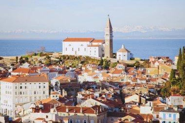 Eski şehir Piran 'ın tarihi merkezinin kırmızı çatıları, günbatımı gökyüzüne ve Adriyatik denizine karşı ana kilise. Hava manzarası, Slovenya
