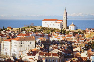 Eski şehir Piran 'ın tarihi merkezinin kırmızı çatıları, günbatımı gökyüzüne ve Adriyatik denizine karşı ana kilise. Hava manzarası, Slovenya