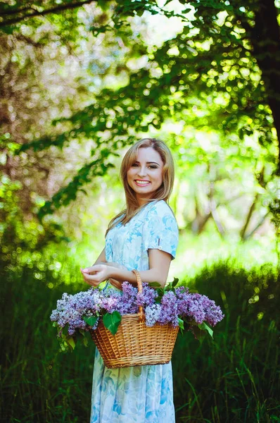 Portret Młodej Kobiety Niebieskiej Sukience Wiosennym Ogrodzie Koszykiem Pełnym Bzu — Zdjęcie stockowe
