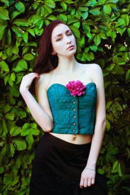 Bahar bahçesinde çiçek açan pembe şakayıklı genç bir kadının portresi. Bahar arka planı. Kadın Günü. Tebrik kartı. 