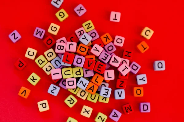 Bunte Holzwürfelperlen Mit Buchstaben Auf Rotem Festlichem Hintergrund Wort Liebe — Stockfoto