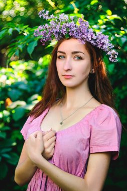 Bahar bahçesinde pembe elbiseli güzel bir kadının portresi. Bahar arka planı. Kadın Günü. Tebrik kartı. 