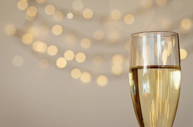 Bokeh arkaplanlı bir kadeh şarap. Düz yatıyordu. Yeni yıl, Noel havası. Tebrik kartı. Parti ve tatil kutlaması konsepti.