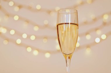 Bokeh arkaplanlı bir kadeh şarap. Düz yatıyordu. Yeni yıl, Noel havası. Tebrik kartı. Parti ve tatil kutlaması konsepti.