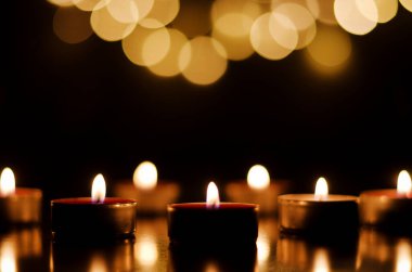 Siyah arka planda şen şakrak mumlar yakmak. Tatil konsepti. Dua ve umut kavramı.