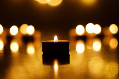 Siyah arka planda şen şakrak mumlar yakmak. Tatil konsepti. Dua ve umut kavramı.