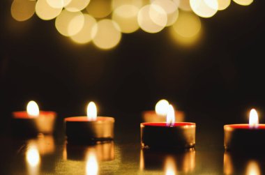 Siyah arka planda şen şakrak mumlar yakmak. Tatil konsepti. Dua ve umut kavramı.