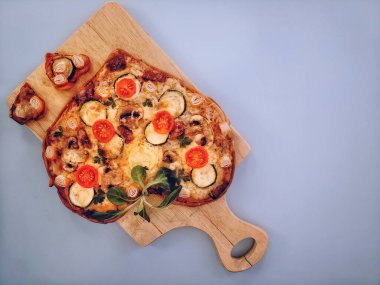 Lezzetli vejetaryen kalbi domatesli, sebzeli ve peynirli pizza. Sevgililer Günü için gri arka planda tahta tahtada. Romantik aşkın yaratıcı yemek konsepti. Üst manzara, düz uzanma.