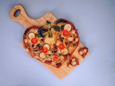 Lezzetli vejetaryen kalbi domatesli, sebzeli ve peynirli pizza. Sevgililer Günü için gri arka planda tahta tahtada. Romantik aşkın yaratıcı yemek konsepti. Üst manzara, düz uzanma.