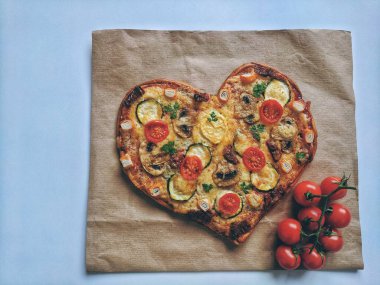Lezzetli vejetaryen kalbi domatesli, sebzeli ve peynirli pizza. Mavi arka planda Sevgililer Günü için. Romantik aşkın yaratıcı yemek konsepti. Üst manzara, düz uzanma.