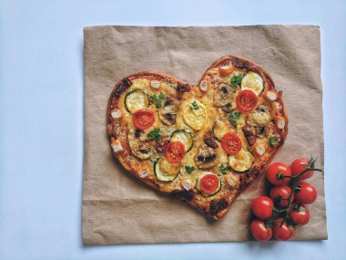 Lezzetli vejetaryen kalbi domatesli, sebzeli ve peynirli pizza. Mavi arka planda Sevgililer Günü için. Romantik aşkın yaratıcı yemek konsepti. Üst manzara, düz uzanma.