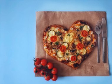 Lezzetli vejetaryen kalbi domatesli, sebzeli ve peynirli pizza. Mavi arka planda Sevgililer Günü için. Romantik aşkın yaratıcı yemek konsepti. Üst manzara, düz uzanma.