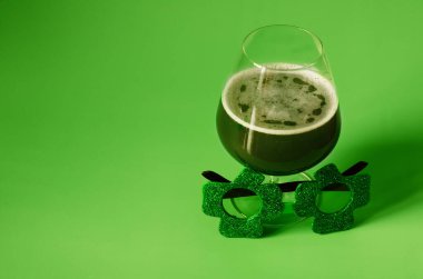 Aziz Patrick Günü konseptin kutlu olsun. Yeşil arka planda bir bardak yeşil bira ve parti bardakları. Tebrik kartı. Uzayı kopyala Üst görünüm. 