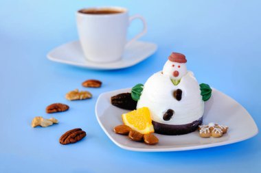 Beyaz tabakta yenilebilir kardan adam şeklinde dondurma ve kahve fincanı yakın. Üst Manzara. Noel ve Yeni Yıl bayramı tatlıları için yaratıcı bir fikir. Çocuklar için komik yemek fikri..