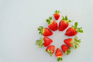 Neşeli gri arka plan. Tabakta taze olgun çilekler, yakın plan. Sevgililer Günü. Yemek geçmişi. Yaratıcı tebrik kartı. Düz yatış, üst görünüm.