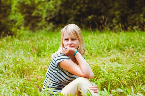 魅力的な幸せなブロンド若いです女性リラックスし フィールドに座っています緑の草とともに夏だけで — ストック写真
