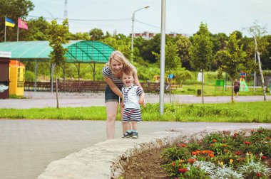 Mutlu aile kavramı. Anne ve oğlu güneşli bir günde parkta oynuyor ve bir yaz yürüyüşünde gülüyorlar. Aile tatili ve birliktelik, seçici odaklanma