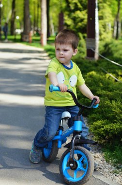 Mutlu aile kavramı. Anne ve oğlu, güneşli bir günde parkta oynuyor ve bahar yürüyüşünde gülüyorlar. Aile tatili ve birliktelik, seçici odaklanma