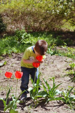 Mutlu aile kavramı. Parkta oynayan, oyun oynayan ve güneşli bir günde bahar yürüyüşünde gülen küçük neşeli çocuk. Aile tatili ve birliktelik, seçici odaklanma. 
