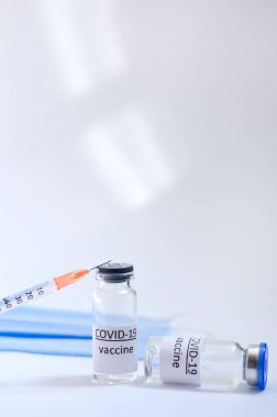 Aşı konseptinin yaratıcı fikirleri. Tıbbi maskeli şırınga ve aşı şişeleriyle COVID-19 'a karşı aşı için en iyi görüntü. Koronavirüs salgını. Boşluğu kopyala. 