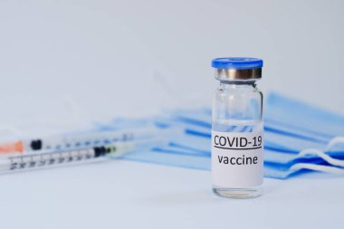 Aşı konseptinin yaratıcı fikirleri. Tıbbi maskeli şırınga ve aşı şişeleriyle COVID-19 'a karşı aşı için en iyi görüntü. Koronavirüs salgını. Boşluğu kopyala. 