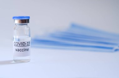 Aşı konseptinin yaratıcı fikirleri. Tıbbi maskeli şırınga ve aşı şişeleriyle COVID-19 'a karşı aşı için en iyi görüntü. Koronavirüs salgını. Boşluğu kopyala. 