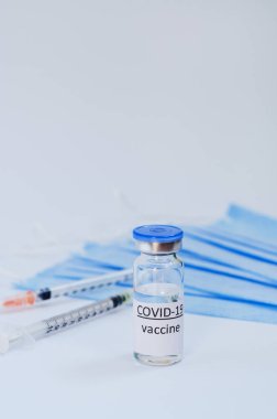 Aşı konseptinin yaratıcı fikirleri. Tıbbi maskeli şırınga ve aşı şişeleriyle COVID-19 'a karşı aşı için en iyi görüntü. Koronavirüs salgını. Boşluğu kopyala. 