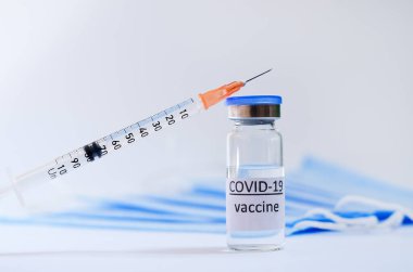 Aşı konseptinin yaratıcı fikirleri. Tıbbi maskeli şırınga ve aşı şişeleriyle COVID-19 'a karşı aşı için en iyi görüntü. Koronavirüs salgını. Boşluğu kopyala. 