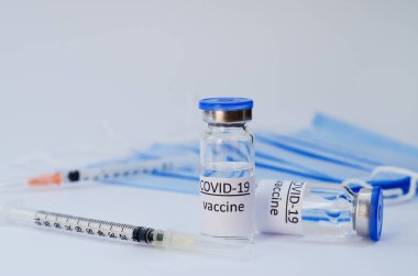 Aşı konseptinin yaratıcı fikirleri. Tıbbi maskeli şırınga ve aşı şişeleriyle COVID-19 'a karşı aşı için en iyi görüntü. Koronavirüs salgını. Boşluğu kopyala. 