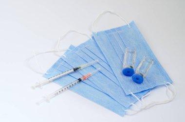 Aşı konseptinin yaratıcı fikirleri. Tıbbi maskeli şırınga ve aşı şişeleriyle COVID-19 'a karşı aşı için en iyi görüntü. Koronavirüs salgını. Boşluğu kopyala. 