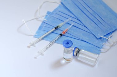 Aşı konseptinin yaratıcı fikirleri. Tıbbi maskeli şırınga ve aşı şişeleriyle COVID-19 'a karşı aşı için en iyi görüntü. Koronavirüs salgını. Boşluğu kopyala. 