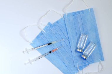 Aşı konseptinin yaratıcı fikirleri. Tıbbi maskeli şırınga ve aşı şişeleriyle COVID-19 'a karşı aşı için en iyi görüntü. Koronavirüs salgını. Boşluğu kopyala. 