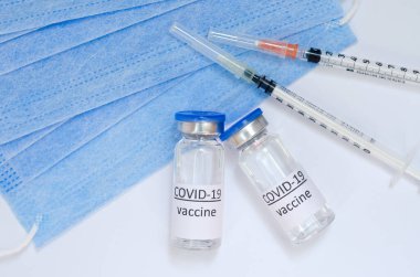 Aşı konseptinin yaratıcı fikirleri. Tıbbi maskeli şırınga ve aşı şişeleriyle COVID-19 'a karşı aşı için en iyi görüntü. Koronavirüs salgını. Boşluğu kopyala. 