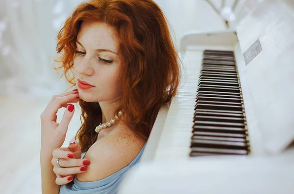 Güzel kızıl saçlı, mavi gözlü ve çilli genç bayan piyanist stüdyoda bir piyanonun yanında oturuyor ve müzik öğreniyor. Müzik yapmanın yaratıcı süreci.