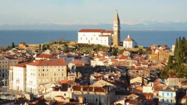 Eski şehir Piran 'ın tarihi merkezinin kırmızı çatıları, günbatımı gökyüzüne ve Adriyatik denizine karşı ana kilise. Hava manzarası, Slovenya