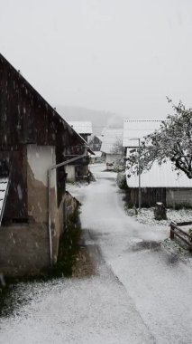 Köyün üzerindeki kar manzarası ve kışın soğuk bir günde yolu kaplayan kar manzarası. Bohinj, Slovenya. 