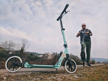 Portoroz, Slovenya. 02.26.2020. Bir adam sokakta normal bir scooter kullanıyor. Aktif yaşam pozisyonu. Spor konsepti. Ekolojik taşıma tipi. 