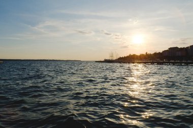 Slovenya kıyısındaki Picturesque sahil beldesi yazın turuncu gün batımı gökyüzüne karşı. Akşamları Adriyatik Denizi manzarası. Seyahat kavramı. 