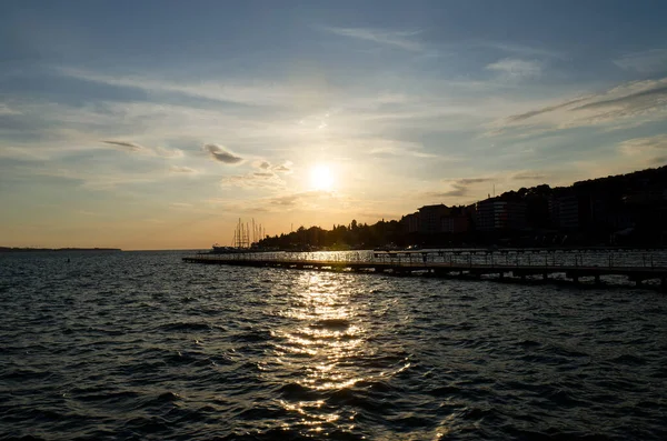 夏にはオレンジ色の夕日の空に対してスロベニアの海岸沿いの美しい海辺のリゾートタウン 夕方にアドリア海への景色 旅行のコンセプト — ストック写真