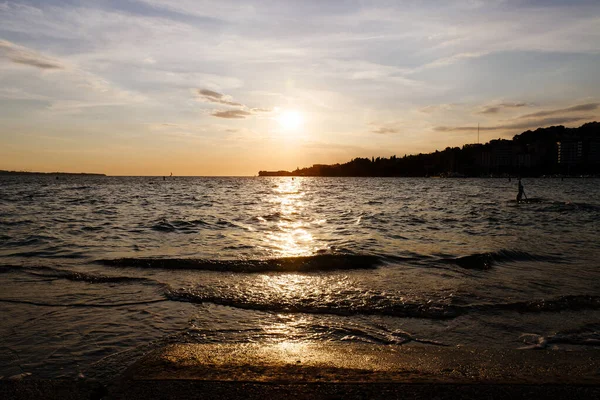 Slovenya kıyısındaki Picturesque sahil beldesi yazın turuncu gün batımı gökyüzüne karşı. Akşamları Adriyatik Denizi manzarası. Seyahat kavramı. 