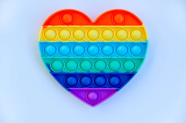 stock image Top view of colorful markers and anti stress sensory toy pop it rainbow heart on blue background close up. Creative and funny concepts of children toys. Popular toy. Trend toy 2021 year.