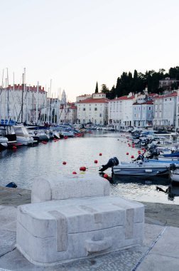 Eski şehir Piran 'ın tarihi merkezinin dar ve boş sokaklarının manzarası gündoğumu gökyüzü ve Adriyatik denizi üzerinde yatlarla. Slovenya sahillerine yaz tatili. 