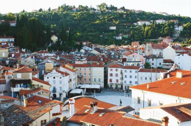 Eski şehir Piran 'ın tarihi merkezinin kırmızı çatıları ve Tartini Meydanı' nın gündoğumu gökyüzü ve Adriyatik Denizi 'ne karşı manzarası. Hava manzaralı, Slovenya kıyısı. 
