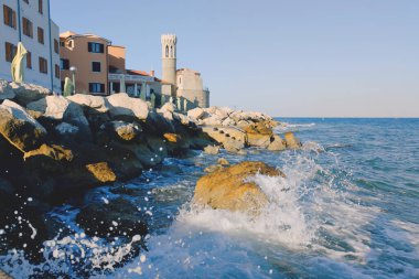 Eski şehir Piran 'ın tarihi merkezinin kırmızı çatıları gündoğumu gökyüzüne ve Adriyatik denizine karşı güzel deniz fenerleriyle. Slovenya 'ya yaz tatili. 