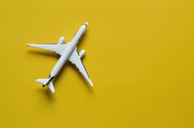 Coronavirus ve seyahat konsepti. Yeni normal bir hayat. Oyuncak uçağın en üst görüntüsü, yakın plan, tıbbi maske. COVID 'i önlemek için yaratıcı fikirler - 19. 