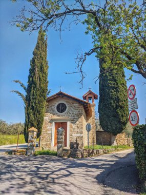 Scenic view of the old small church against pine trees and blue sky in village in Slovenia.  
